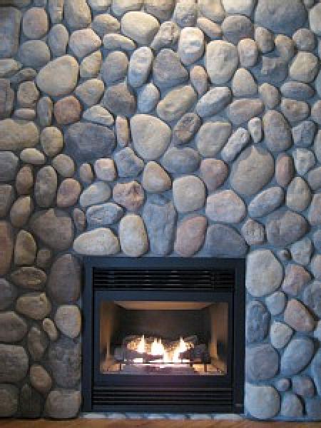 River rock wall surrounding gas fireplace 