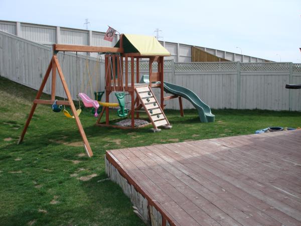 Large private fenced backyard with play centre